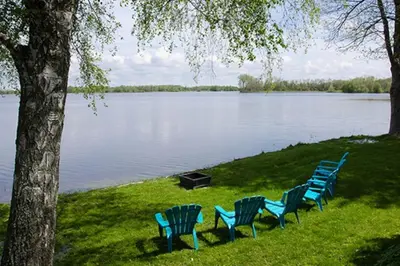 a group of blue chairs sitting next to a lake at Heaven on Huycks Bay in Hillier