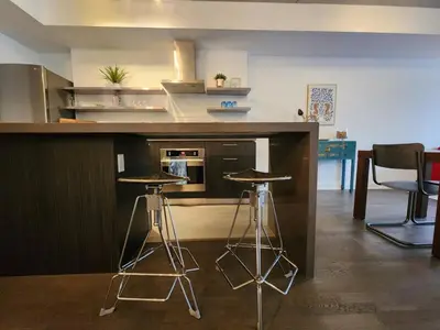 a kitchen with two bar stools and a counter top at Chic 1BDR Loft with Office Space-Heart of Toronto in Toronto