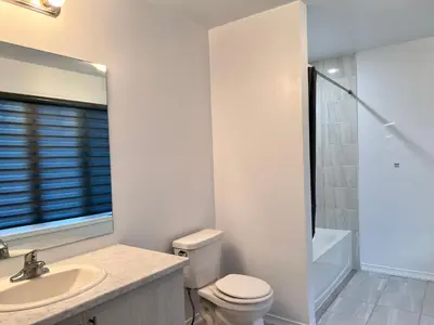 a white bathroom with a toilet and a sink at Spacious 4-Bedroom Home, Comfortably Sleeps 10 in Barrie