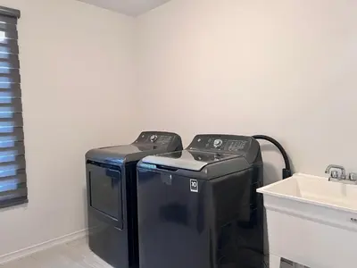 a washer and dryer in a room with a sink at Spacious 4-Bedroom Home, Comfortably Sleeps 10 in Barrie