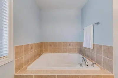 a bath tub in a tiled bathroom with a window at Avid vacation palace in Castlemore , Brampton in Brampton