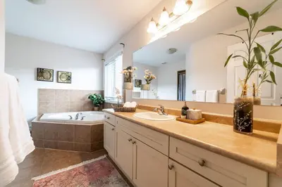 a bathroom with a tub and a large mirror at 4br Near Hilton Falls - Kelso - Gazebo, Workspace in Milton