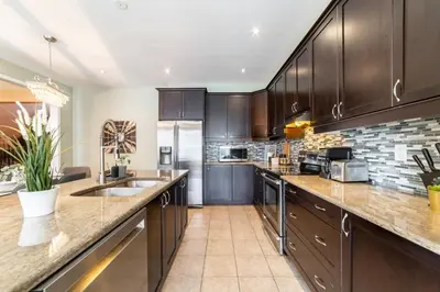 a kitchen with wooden cabinets and a counter top at 4br Near Hilton Falls - Kelso - Gazebo, Workspace in Milton