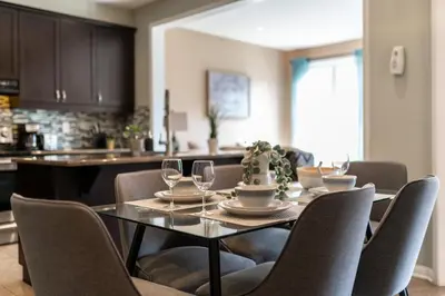 a dining room with a table and chairs and a kitchen at 4br Near Hilton Falls - Kelso - Gazebo, Workspace in Milton