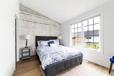 a bedroom with a bed and a brick wall at 2br - Spacious Yard - Canal Bridge, Falls Nearby! in Welland