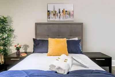 a bedroom with a bed with towels on it at Modern Apartment in a Trendy Neighbourhood in Hamilton