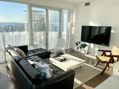 a living room with a couch and a large window at Presidential Suite Heart of Downtown with Stunning View in Toronto