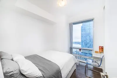 a bedroom with a bed and a large window at Presidential Suite Heart of Downtown with Stunning View in Toronto