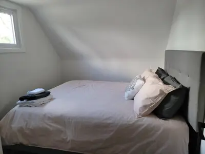 a bedroom with a bed with white sheets and pillows at 2br, Welland Canal, Near Merritt, 20 Min To Falls in Welland