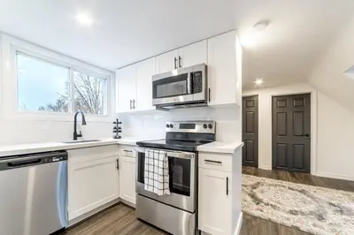 a kitchen with white cabinets and a stove and microwave at 2br, Welland Canal, Near Merritt, 20 Min To Falls in Welland
