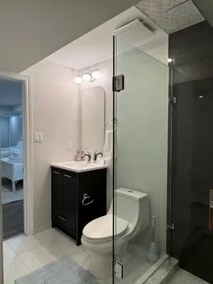 a bathroom with a toilet and a sink and a shower at Spacious Bottom-Floor 2BR Suite in Innisfil