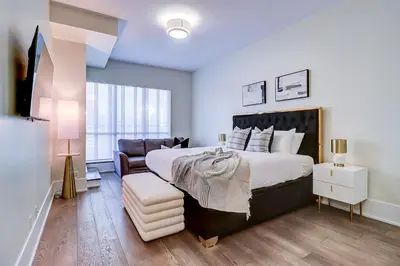 a bedroom with a large bed and a couch at Metropolis Loft - CN Tower in Toronto
