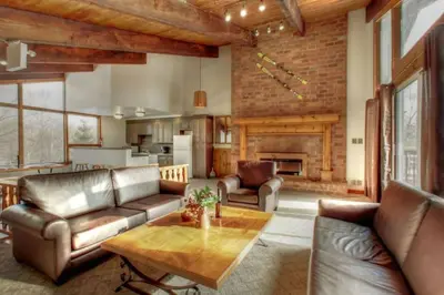 a living room with leather furniture and a fireplace at 8 bdrm Blue Mountain Cottage, Large Groups, Private Beach Access, Hot Tub, Sauna, Ping Pong Table Perfect for Large Groups, Petfriendly in Blue Mountains