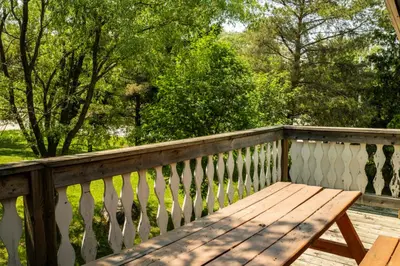 a wooden bench sitting on a wooden deck at 4 Bedroom Cottage near The Village, Private Beach Access, BBQ, Petfriendly in Blue Mountains