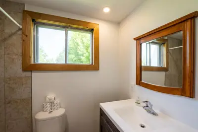 a bathroom with a toilet and a sink and a mirror at 6 bdrm Blue Mountain Cottage, Private Beach Access, Hot Tub, Sauna, Table Tennis, BBQ, Petfriendly in Blue Mountains