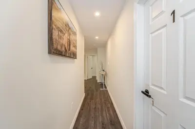 a hallway with a door and a painting on the wall at Cozy basement suites Oakville in Oakville