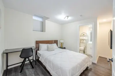 a bedroom with a bed and a desk and a chair at Cozy basement suites Oakville in Oakville