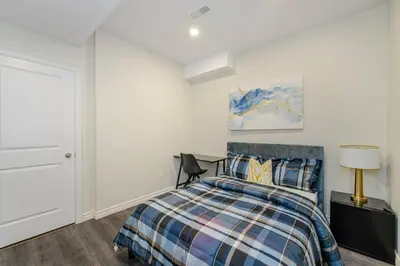 a bedroom with a bed and a desk with a lamp at Cozy basement suites Oakville in Oakville