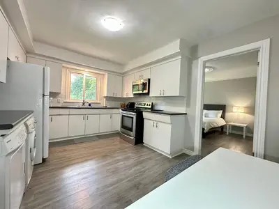 a kitchen with white cabinets and a stove top oven at Mountain View Suite - Sleeps 6 in St. Catharines