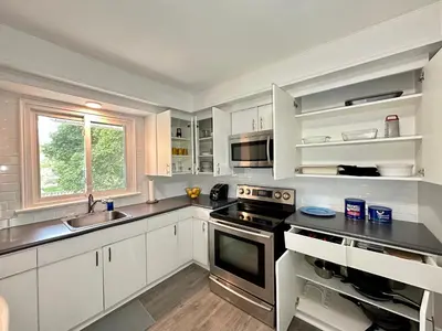 a kitchen with white cabinets and a stove top oven at Mountain View Suite - Sleeps 6 in St. Catharines