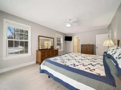 a bedroom with a bed and a dresser and a window at The Captains Lake House in Orillia