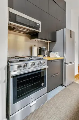 a kitchen with a stainless steel stove and refrigerator at Historic Victorian with Deck and Parking in Toronto