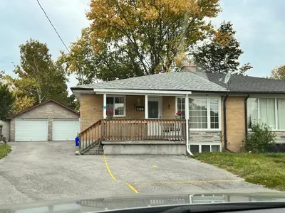 a house with a porch and a driveway at 3 BR GREAT HOUSE WITH ONE parking in Richmond Hill