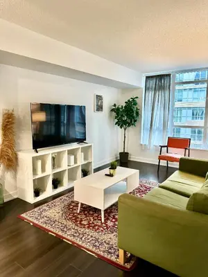 a living room with a couch and a tv at Lush Condo By CNTower - Free Parking in Toronto