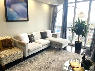 a living room with a white couch and a large window at TVHR - Luxury Condos in Heart of Downtown with Breakfast in Toronto