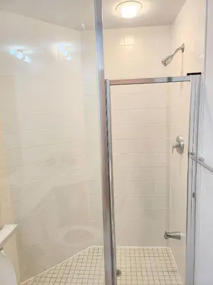 a shower with a glass door in a bathroom at Luxury Suites Steps to CN Tower - Lock in 4 Weeks Enjoy Half OFF in Toronto