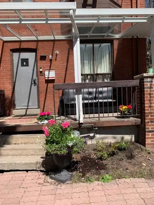 a bench in front of a house with flowers at Pembroke suites in Toronto