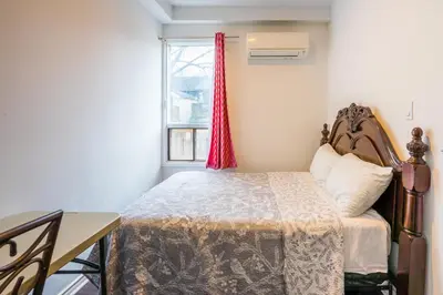 a bedroom with a bed and a desk and a window at Pembroke suites in Toronto