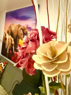 a bunch of flowers in a pot next to a painting at LOVE and Relax at Dream Catcher Retreat in Whitby