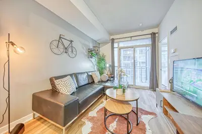 a living room with a couch and a tv at The Snug 1plus1 Suite with Free Parking in Toronto