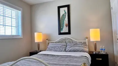 a bedroom with a bed with two lamps and a picture on the wall at \u591a\u4f26\u591a\u6e56\u7554\u522b\u5885\u53cc\u4eba\u95f43 in Bowmanville