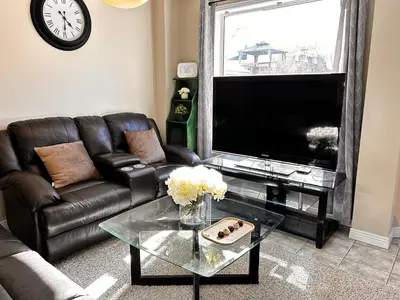 a living room with a leather couch and a glass table at \u591a\u4f26\u591a\u6e56\u7554\u522b\u5885\u53cc\u4eba\u95f43 in Bowmanville