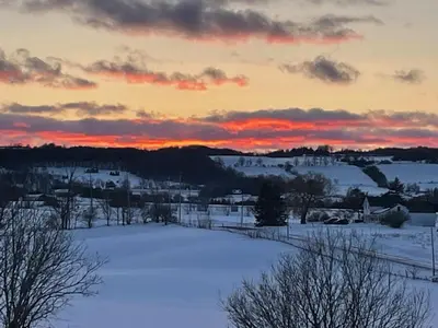 a view of a snowy field with a sunset at Mountain Ash Country Manor and Spa in Creemore
