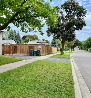 a house with a wooden fence and a sidewalk at Entire Basement Apartment in Mississauga, Etobicoke in Mississauga