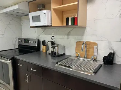 a kitchen counter with a sink and a microwave at Entire Basement Apartment in Mississauga, Etobicoke in Mississauga