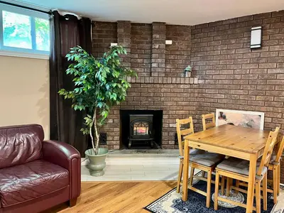 a living room with a table and a fireplace at Entire Basement Apartment in Mississauga, Etobicoke in Mississauga