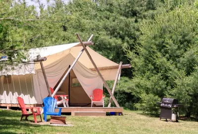a tent with chairs and a grill in the grass at Homegrown Hideaway in Port Dover