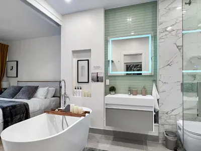 a bathroom with a bed and a tub and a sink at Elegant 2 Bedroom with Parking in Toronto