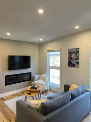 a living room with a blue couch and a table at Elora’s Irvine River Suite in Elora