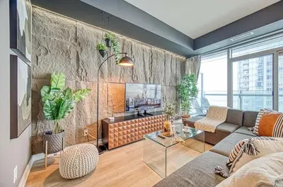 a living room with a couch and a tv at Skyline Retreat Residences in Toronto