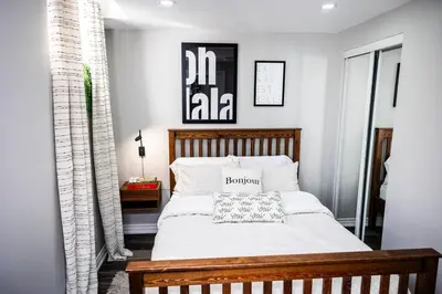 a bedroom with a bed with a wooden headboard at French Charm in Brampton 2 Bdrm Apt in Brampton