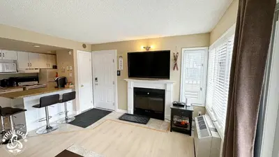a living room with a fireplace and a flat screen tv at Blue Mtn 1 Bedroom with Mountain View in Blue Mountains
