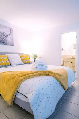 a bed with a yellow and blue blanket on it at Gorgeous Studio Condo in Blue Mountains Sleeps 4 in Blue Mountains