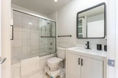 a bathroom with a toilet and a sink and a mirror at Toronto Views ~ Pool ~ BBQ ~ Harbourfront ~ WIFI in Toronto
