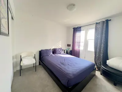 a bedroom with a bed and a chair and a window at Keppel Circle Residence in Brampton