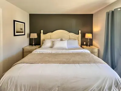 a bedroom with a large white bed with two night stands at Spa Golf Bike in Collingwood